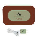 NYP Oliver PEMF Device: Brown charging pad with illuminated nameplate, and matching green wall adapter.