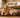Golden retriever and cat resting on a brown PEMF mat with a device, near a food bowl.