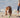 Brown and white Pit Bull terrier running on beach, chasing green ball.