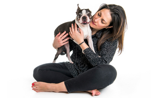 Woman cuddling her Boston Terrier dog