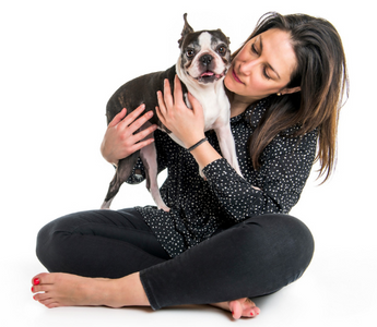 Woman cuddling her Boston Terrier dog