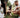 Couple petting their Akita Inu dog in a park