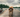 Wet golden retriever dog walking on a wooden dock towards the camera, lake and cloudy sky in the background.