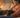 Woman comforting a black lab on a couch, reflecting on pet care.