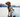 Two dogs, a Wirehaired Pointing Griffon and a Jack Russell Terrier, sit together on a frozen lake.
