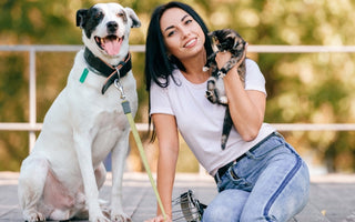 Happy woman with her dog and kitten outdoors