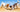 Two dogs playfully digging in the sand at the beach.