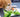 Golden retriever dog enjoying a healthy salad of lettuce, carrots, and cucumber.