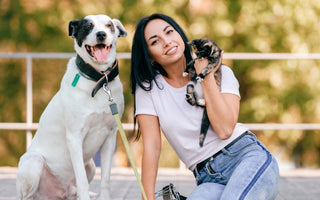 Happy woman with her dog and cat outdoors