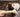Happy Labrador Retriever dog eagerly chewing on a large, beige Nylabone.