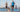 Fit couple jogging with golden retriever dog by the river