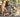 Girl sitting with two Golden Retrievers in a park