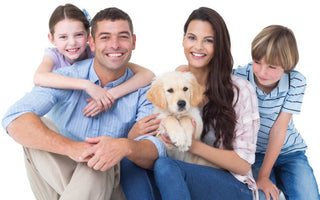 Happy family with two children and a golden retriever puppy