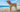 Golden Labrador Retriever on beach, holding tennis ball