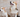 Adult and puppy Pembroke Welsh Corgis sitting together.