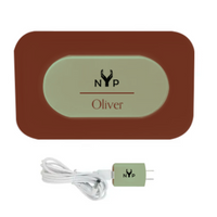 NYP Oliver PEMF Device: Brown charging pad with illuminated nameplate, and matching green wall adapter.